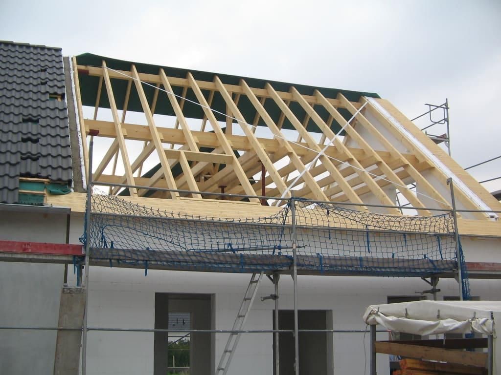 Das Dach eines Gebäudes wird mit Holzbalken gebaut