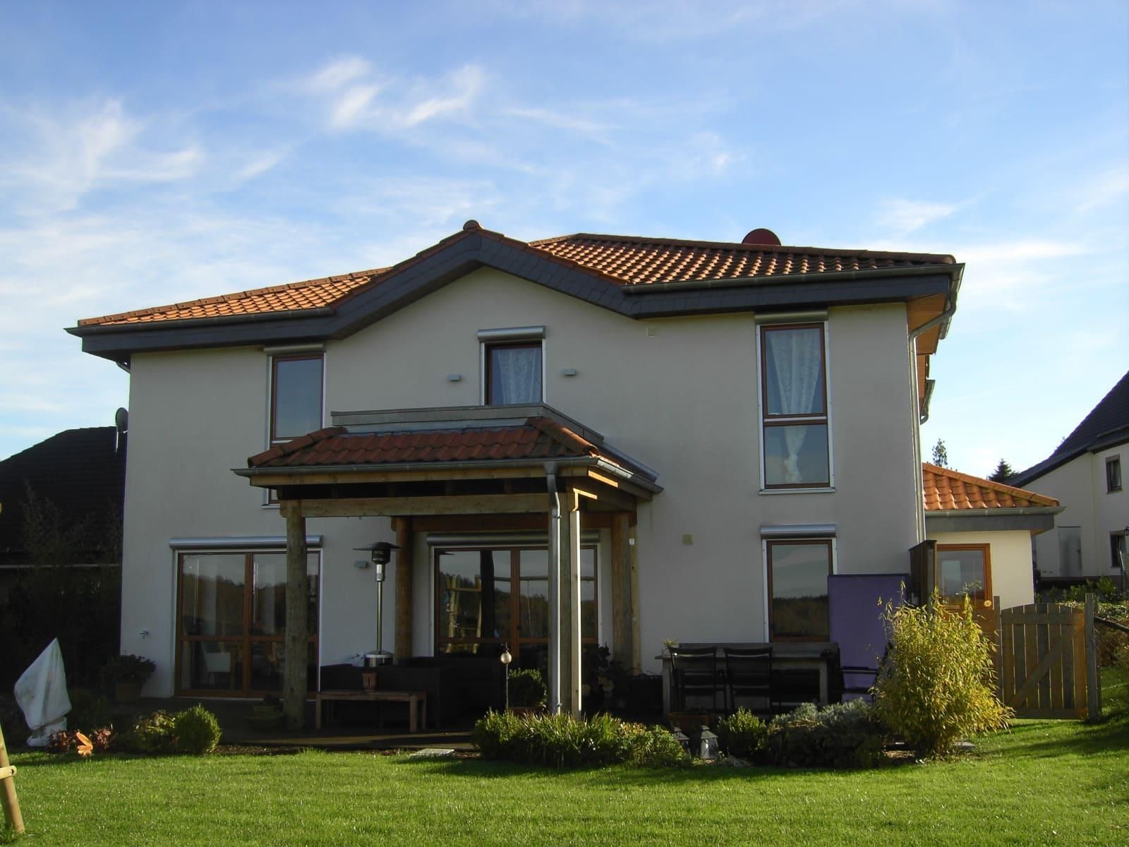 Ein großes weißes Haus mit einem roten Ziegeldach