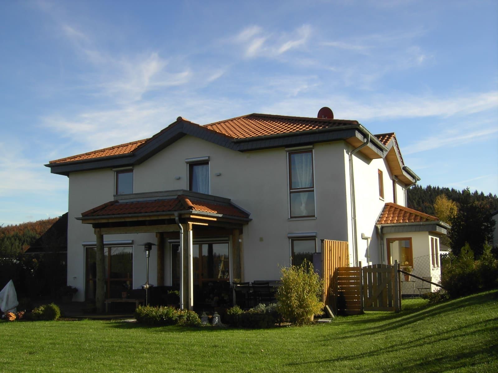 Ein großes weißes Haus mit einem roten Ziegeldach