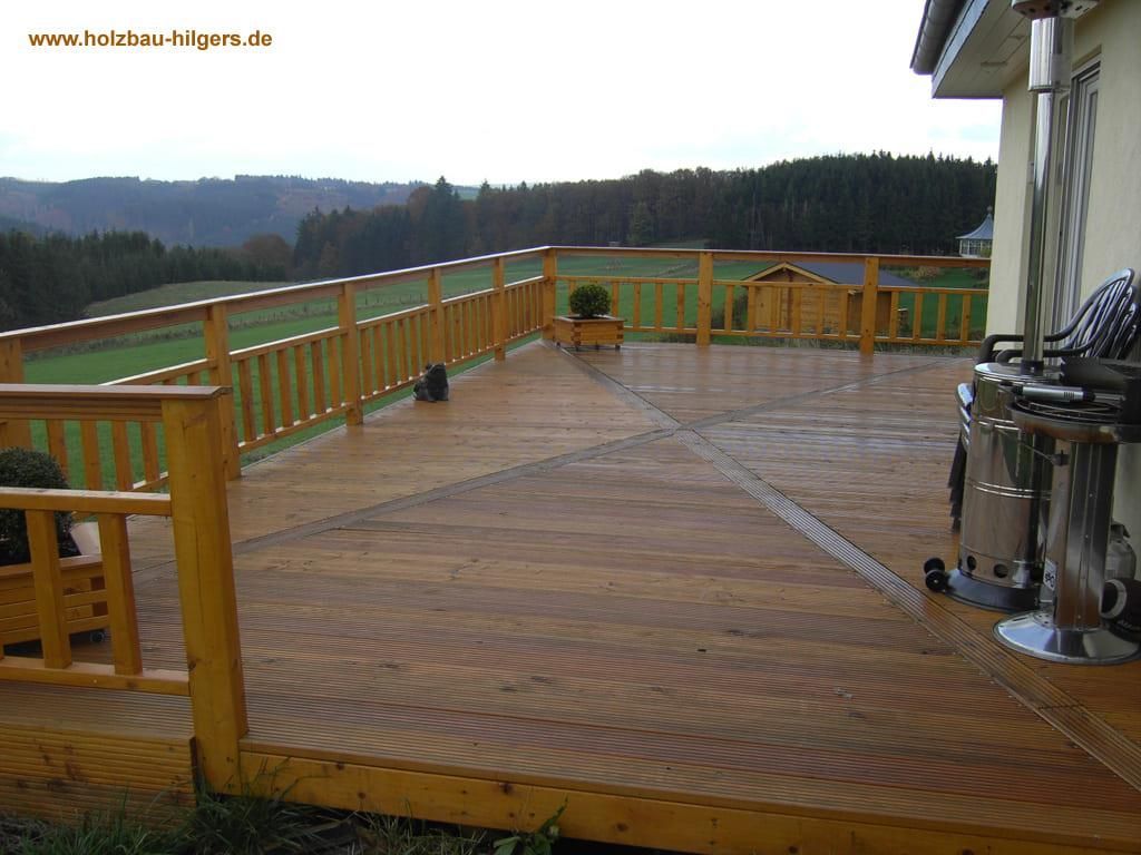 Eine Holzterrasse mit Blick auf ein üppiges grünes Feld
