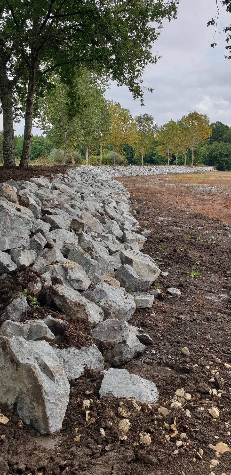 Une digue en pierre autour d'un étang vide