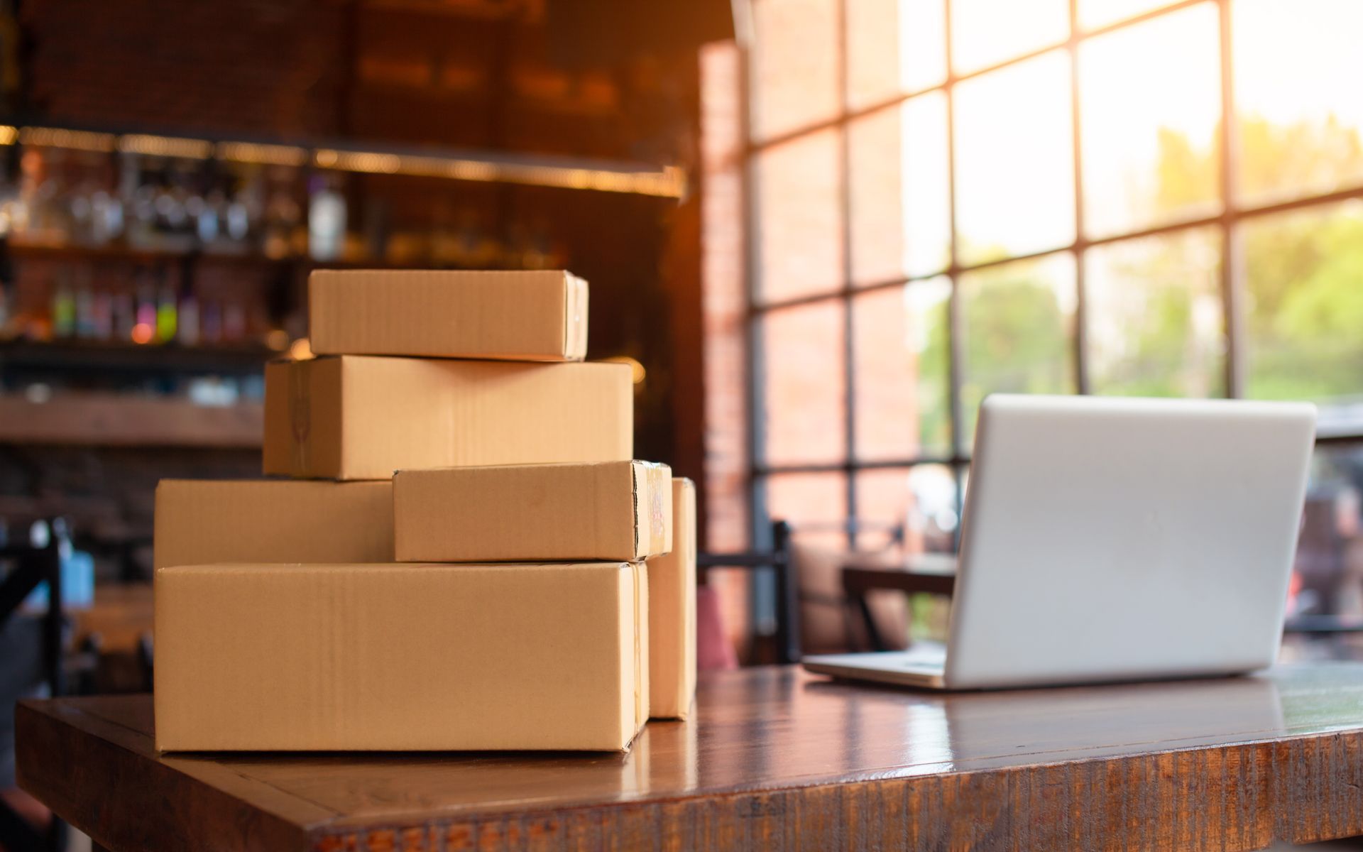 Des colis sur un bureau à côté d'un ordinateur portable.