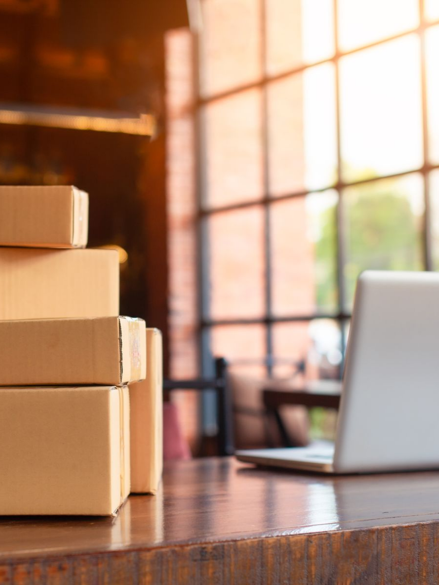 Des colis à côté d'un ordinateur sur un bureau.