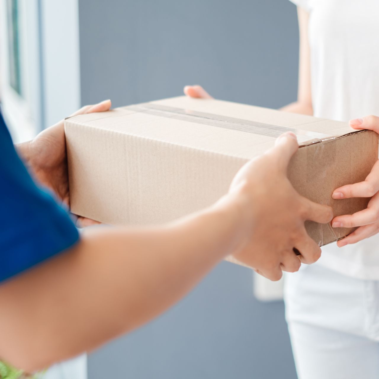 2 personnes tiennent un colis.