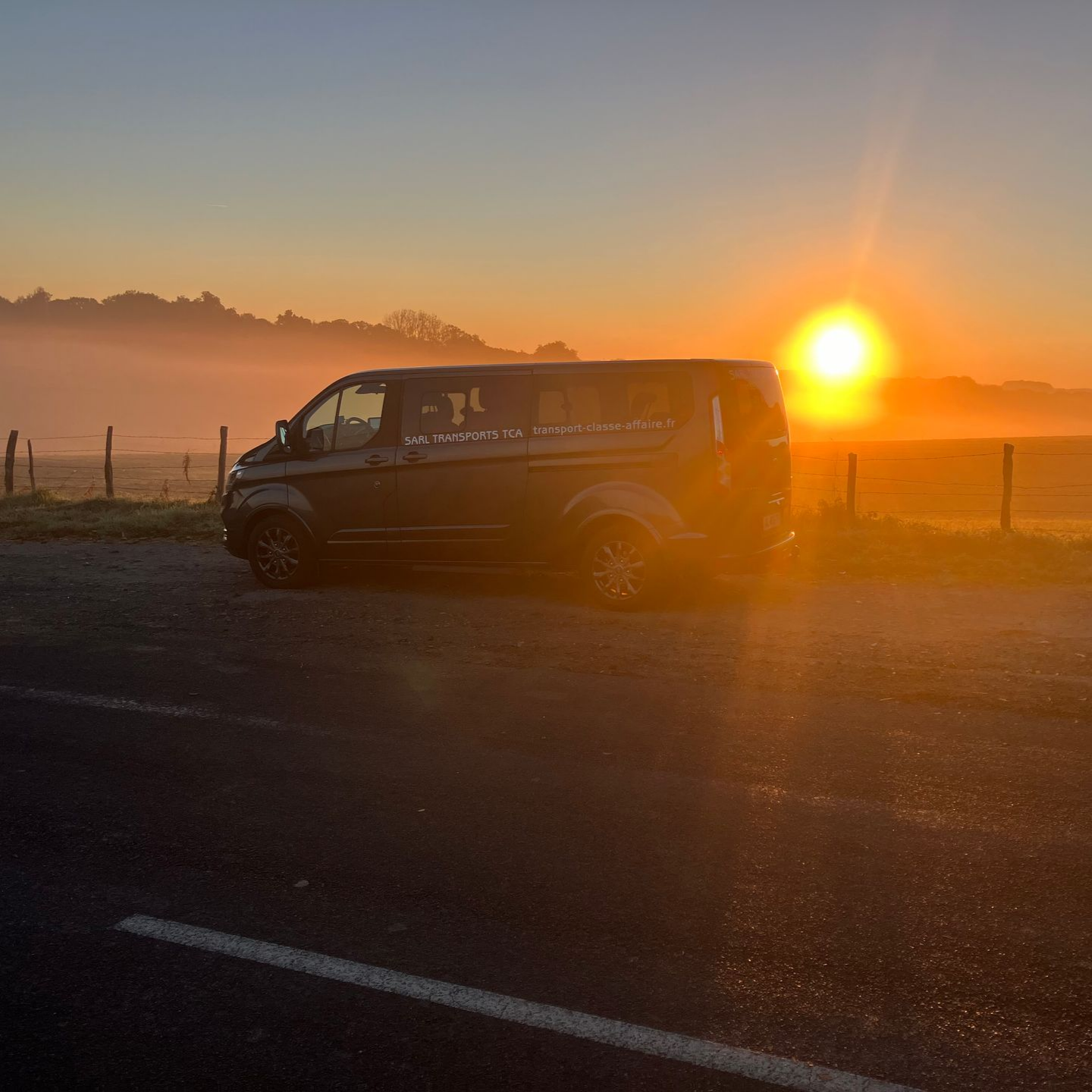 Mini bus garé sur le côté de la route avec le couché de soleil.