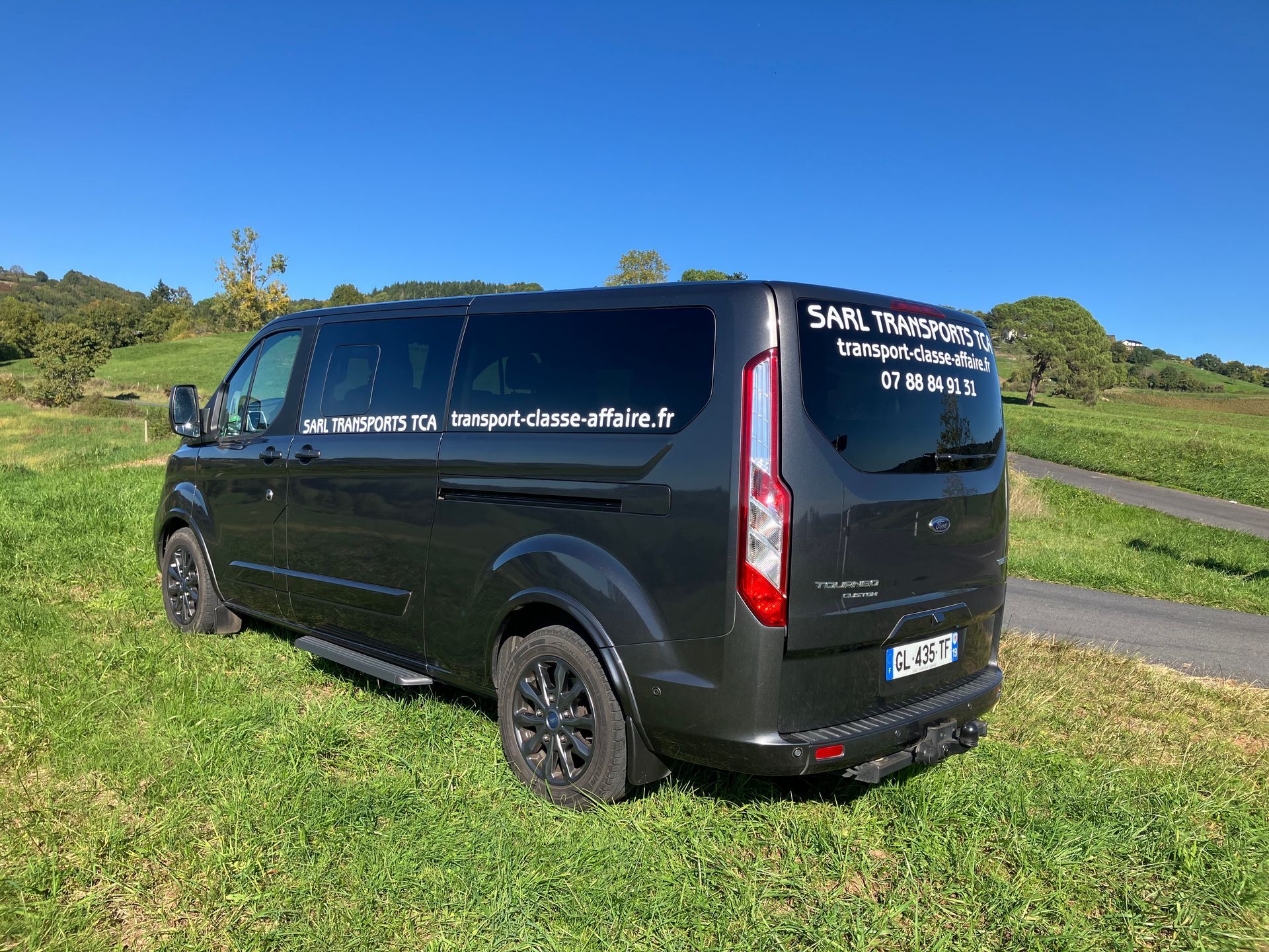 Minibus stationné sur l'herbe au bord de la route.