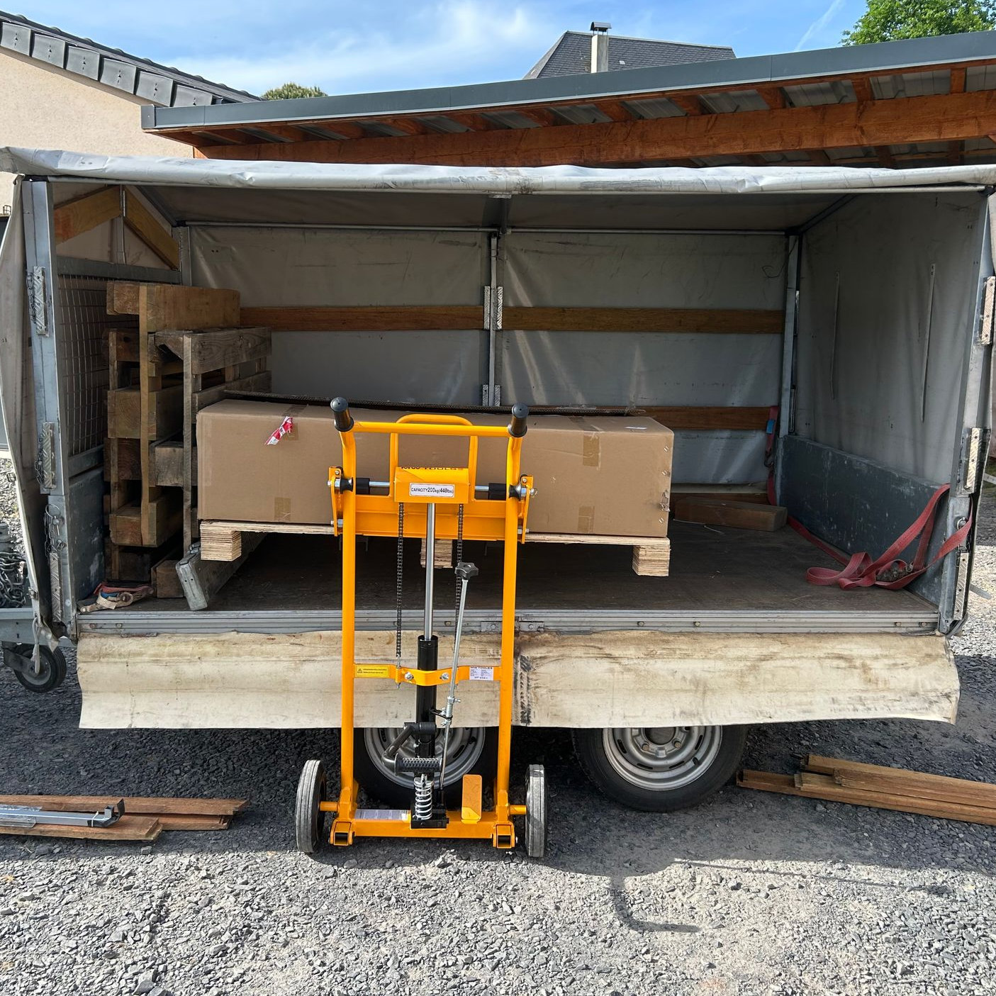Hayon élévateur jaune devant une camionnette