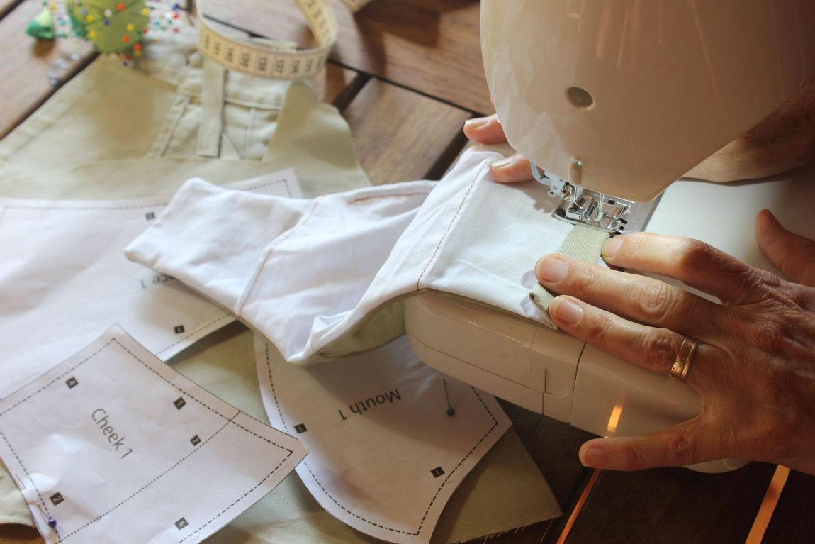 Una persona está usando una máquina de coser para coser un trozo de tela.