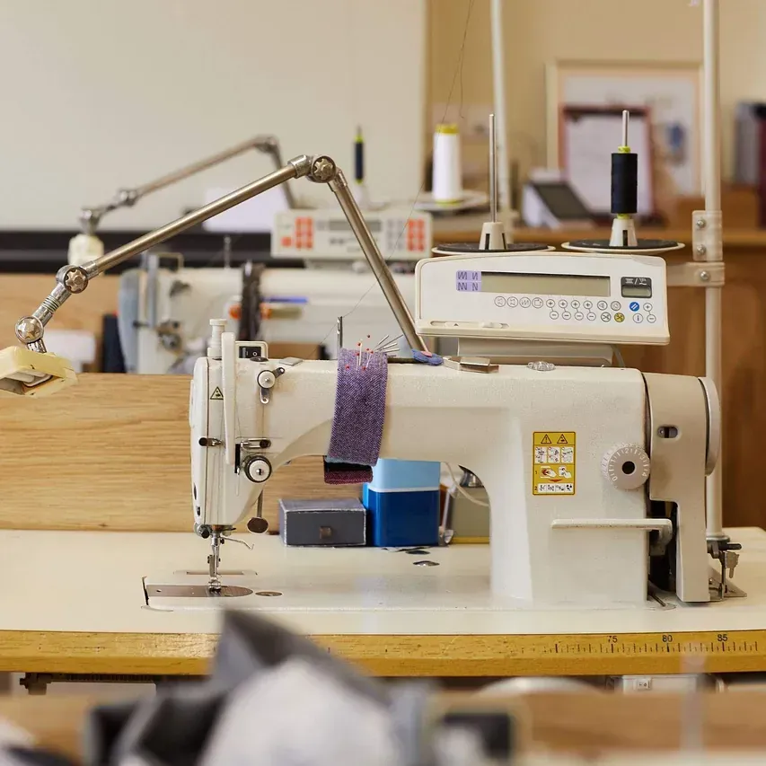 Una máquina de coser está sobre una mesa de madera.