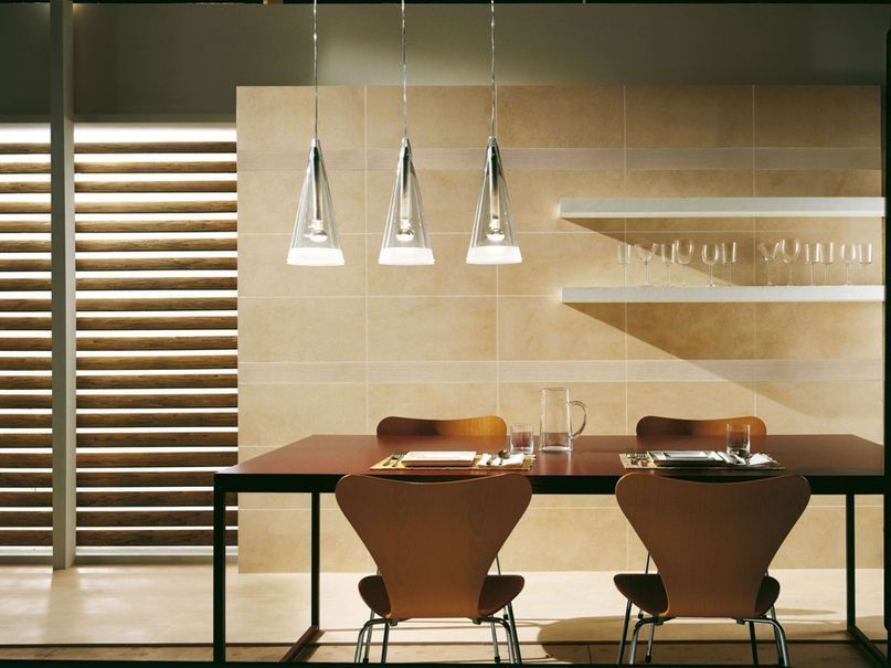 Esstisch aus Holz mit Natursteinfliesen im Hintergrund