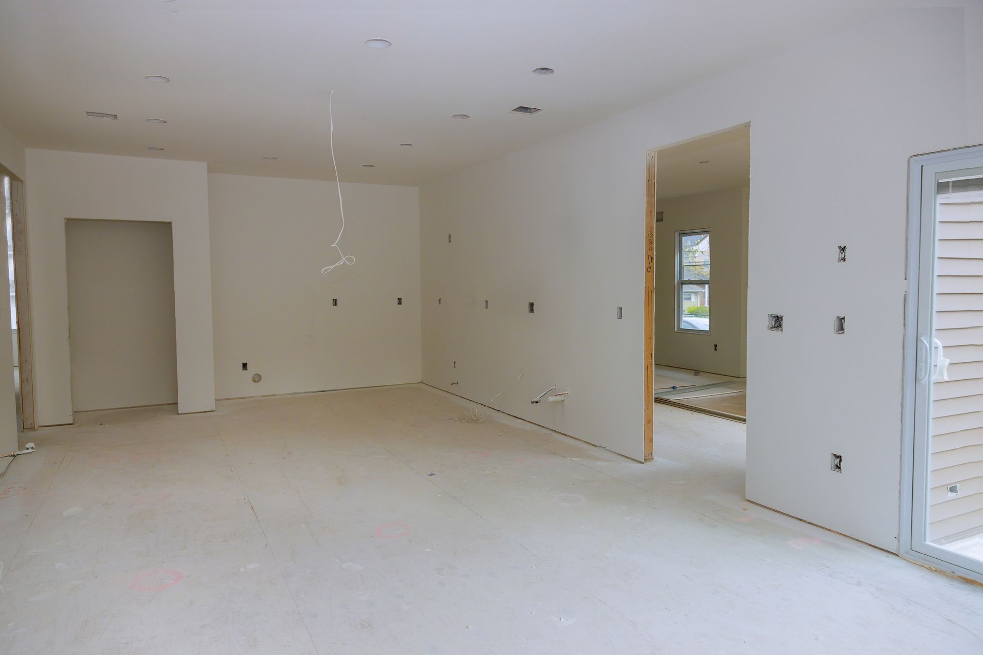 Pièce vide et inachevée avec murs, cloisons sèches et ouvertures de portes en construction.