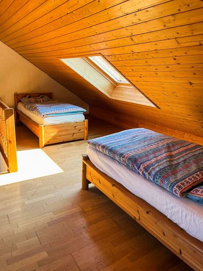 Zwei Einzelbetten unter einer Dachschraege mit Fenster im Kaminzimmer im Hof Gottesbueren bei Warburg