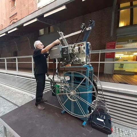 Un hombre está trabajando en una máquina fuera de un edificio.