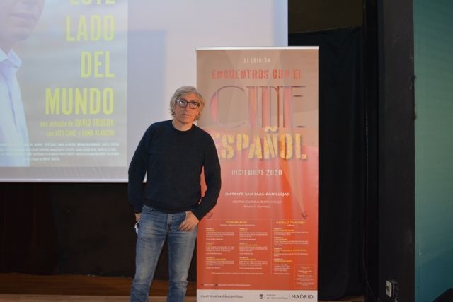 Un hombre parado frente a un cartel que dice que español