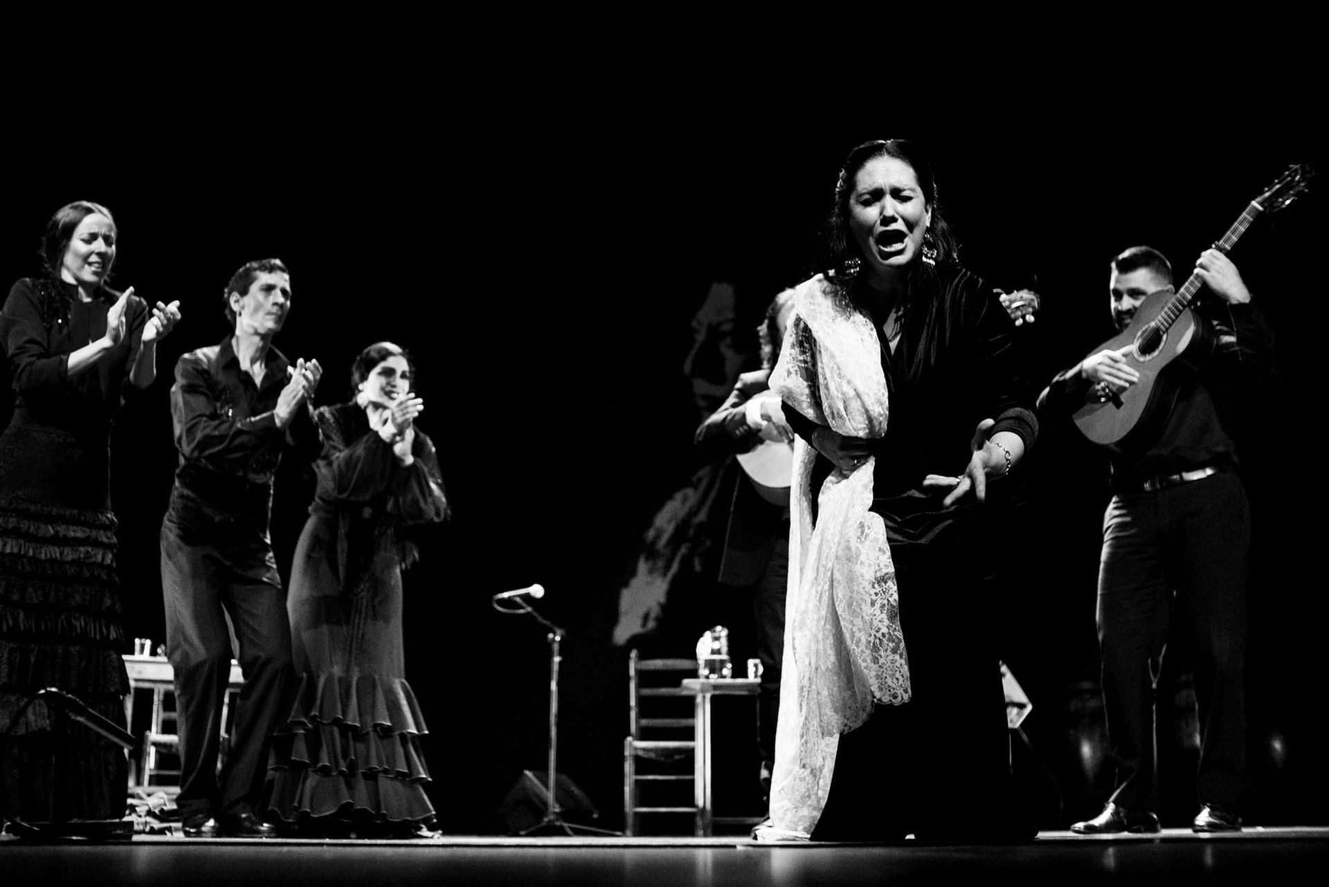 Una fotografía en blanco y negro de un grupo de personas bailando en un escenario.