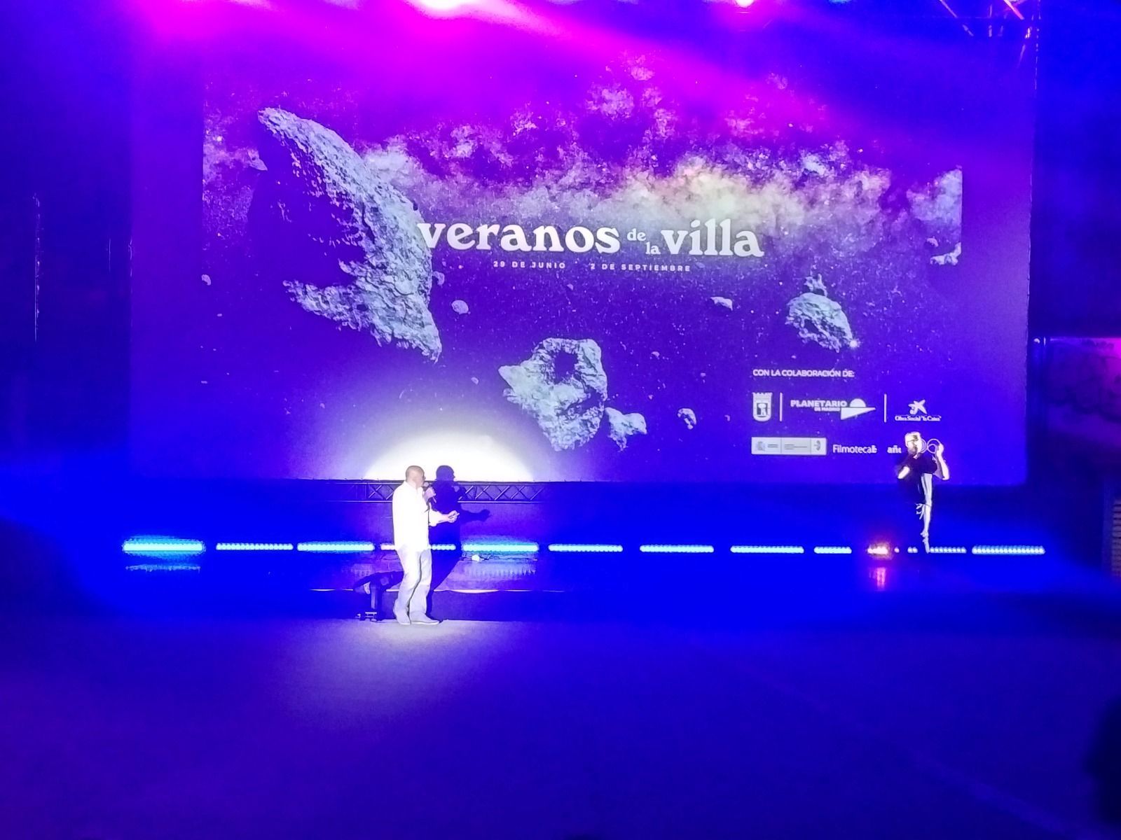 Un escenario con una pantalla grande que dice veranos villa