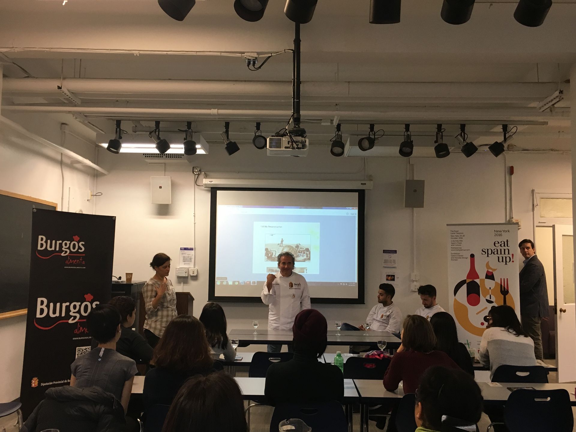 Un hombre está dando una presentación a un grupo de personas en un aula.