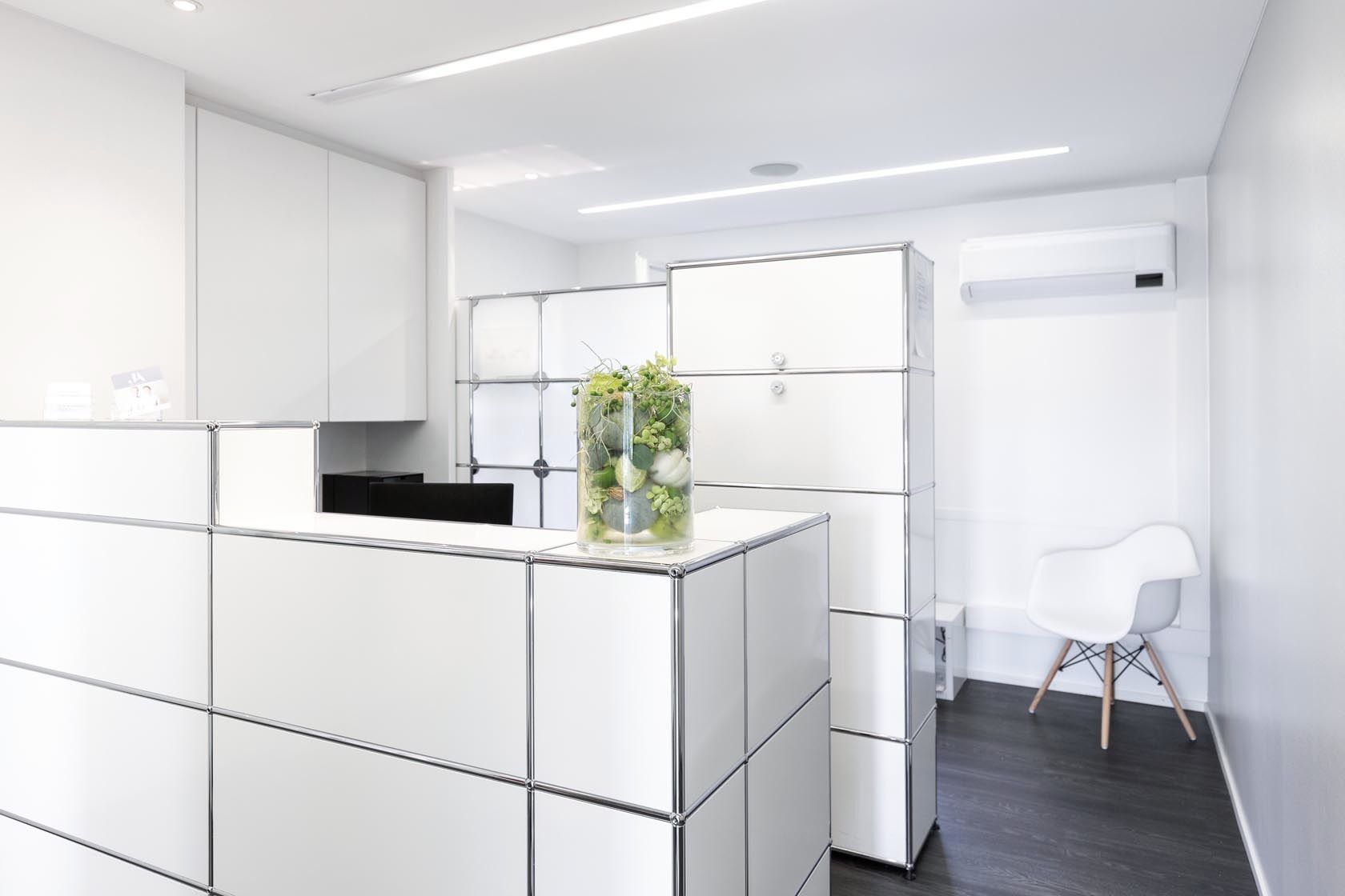 Ein weißer Rezeptionstresen mit einer Vase mit Blumen darauf