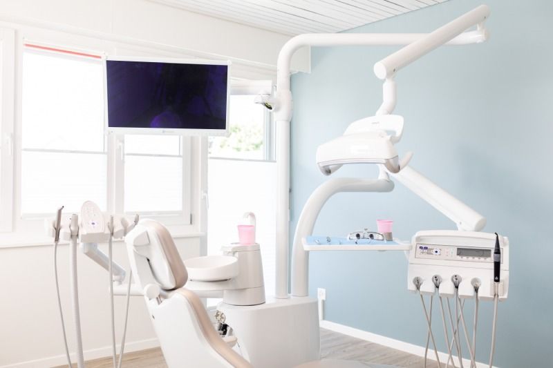 Zahnarztraum mit einem Zahnarztstuhl und einem Monitor. Foto von der Zahnarztpraxis Dr. Judith Aufenanger.