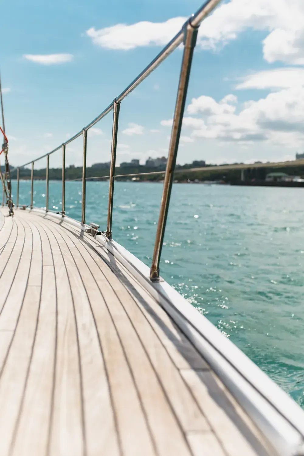 Velero en aguas tranquilas con un mástil alto contra un cielo pastel.