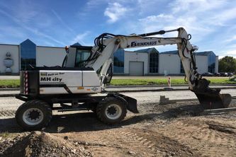 Weißer Bagger auf Sand