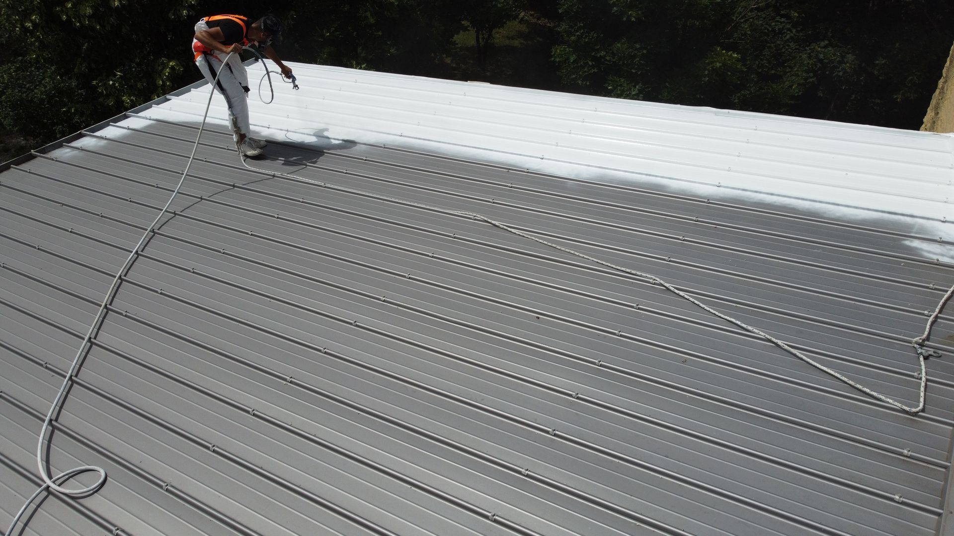 Pose d'une peinture thermo-réfléchissante sur un toit en tôle