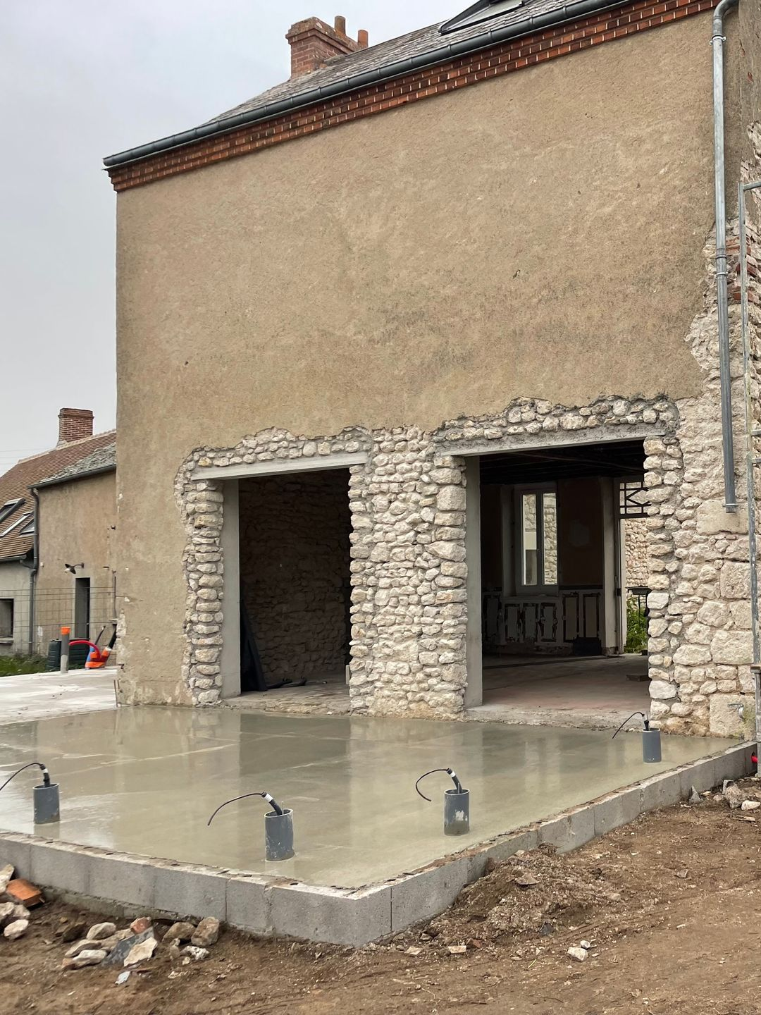 Extérieur de la maison avec deux ouvertures pour baies vitrées.