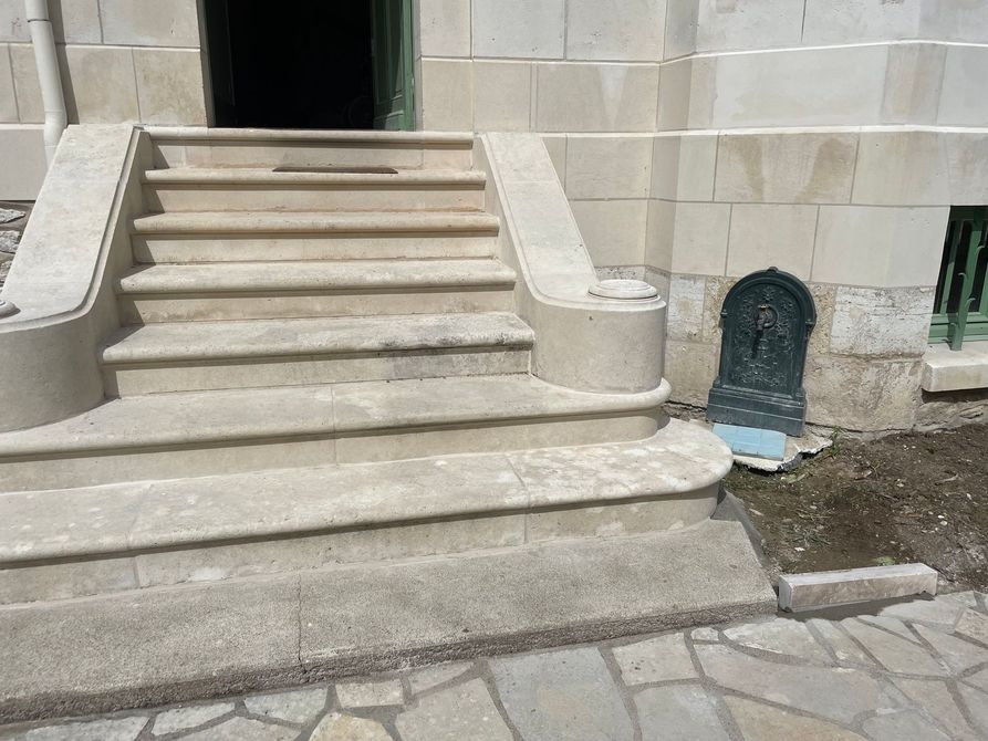 Des marches en pierre mènent à l'entrée d'un bâtiment.