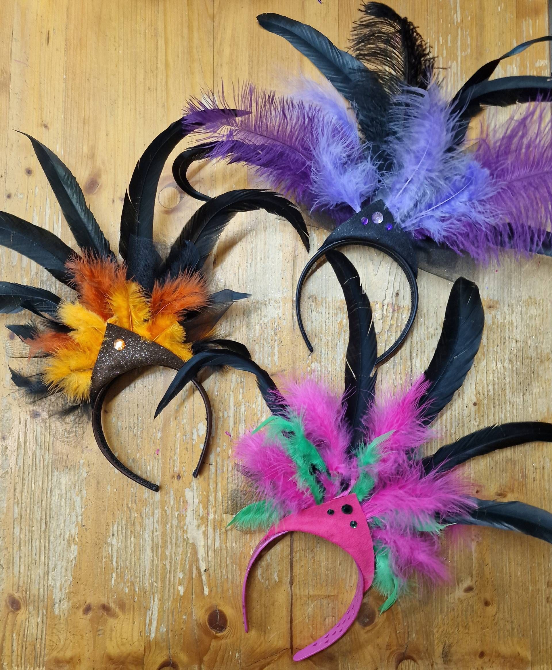 Une paire de boucles d'oreilles en plumes est posée sur un chevalet en bois.