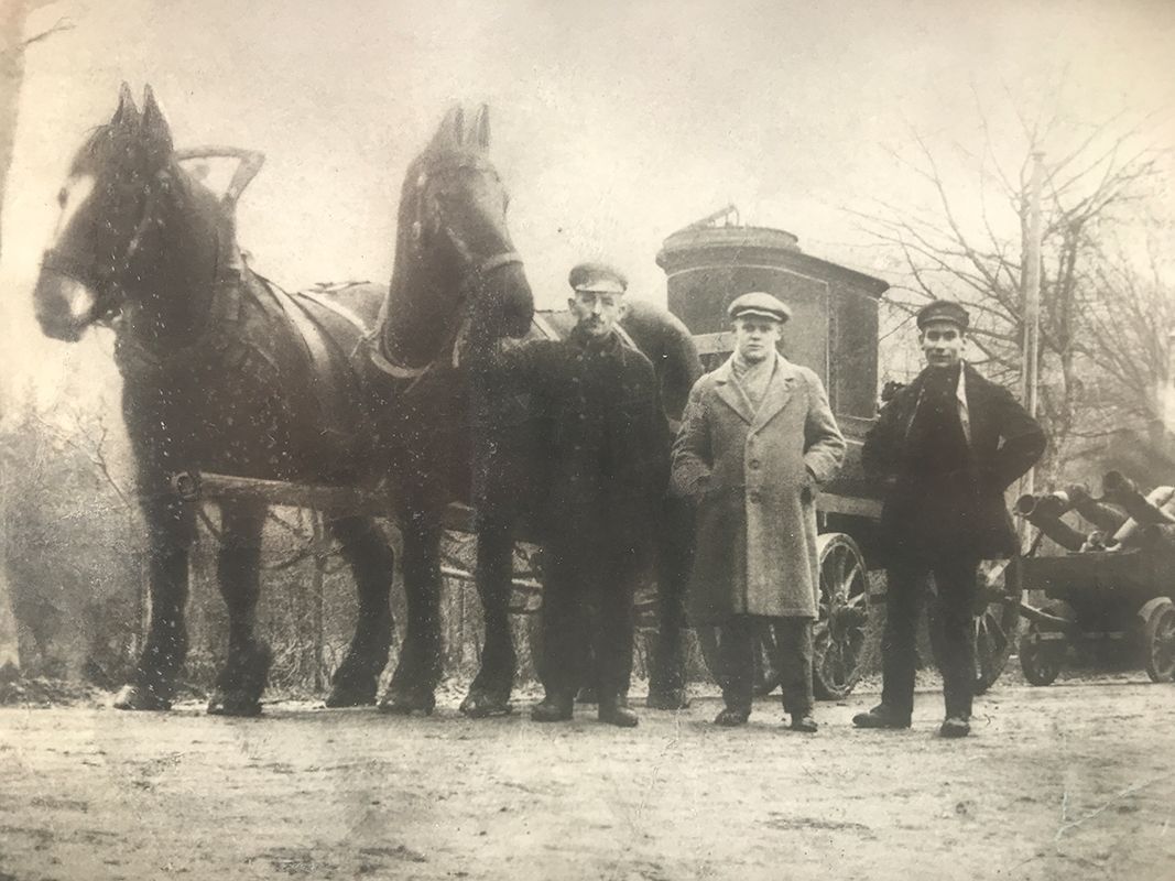 Historisches Bild von drei Männern und zwei Pferden, die für die Grubenentleerung arbeiten