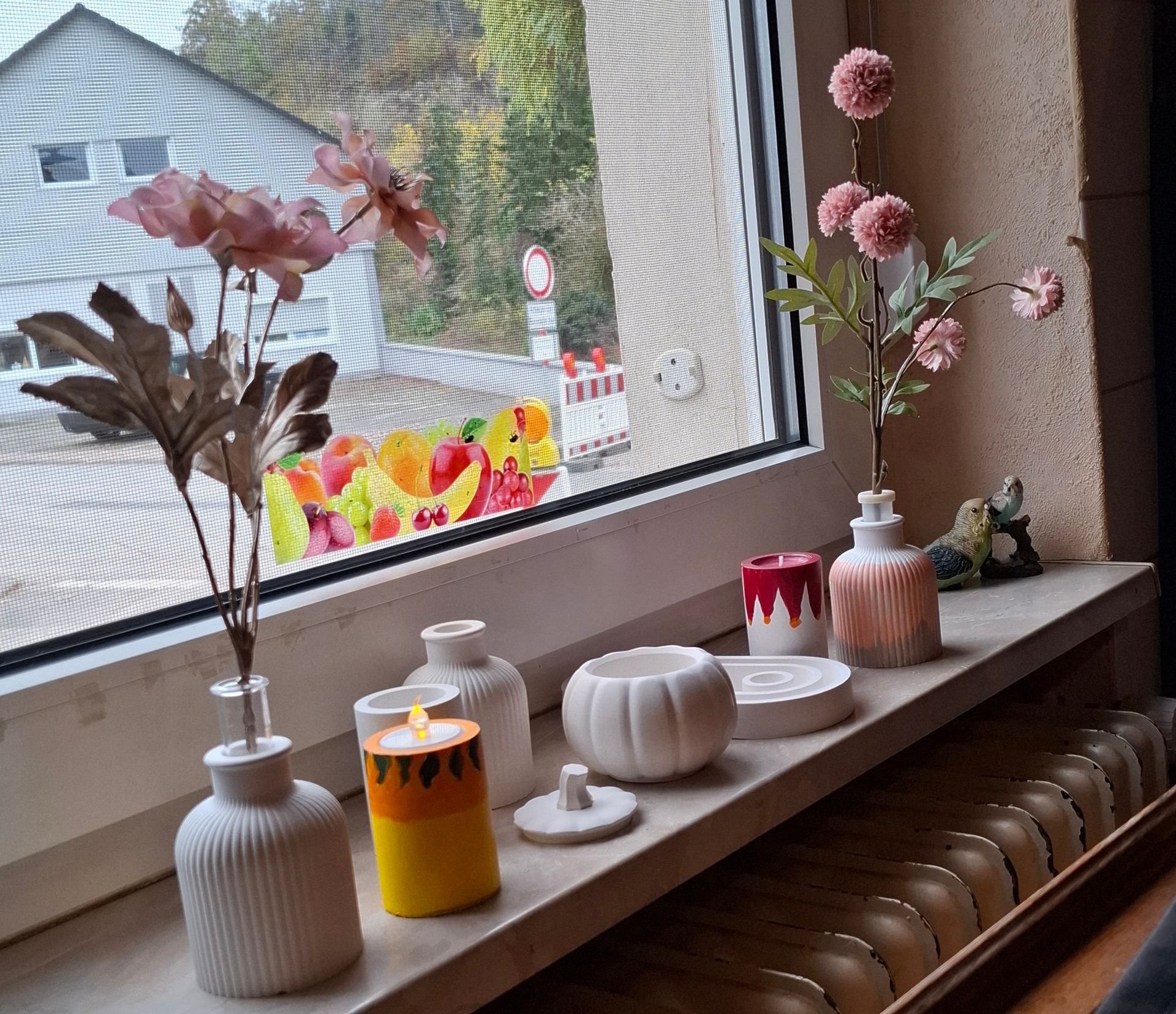 Eine Fensterbank mit Vasen und Kerzen darauf.