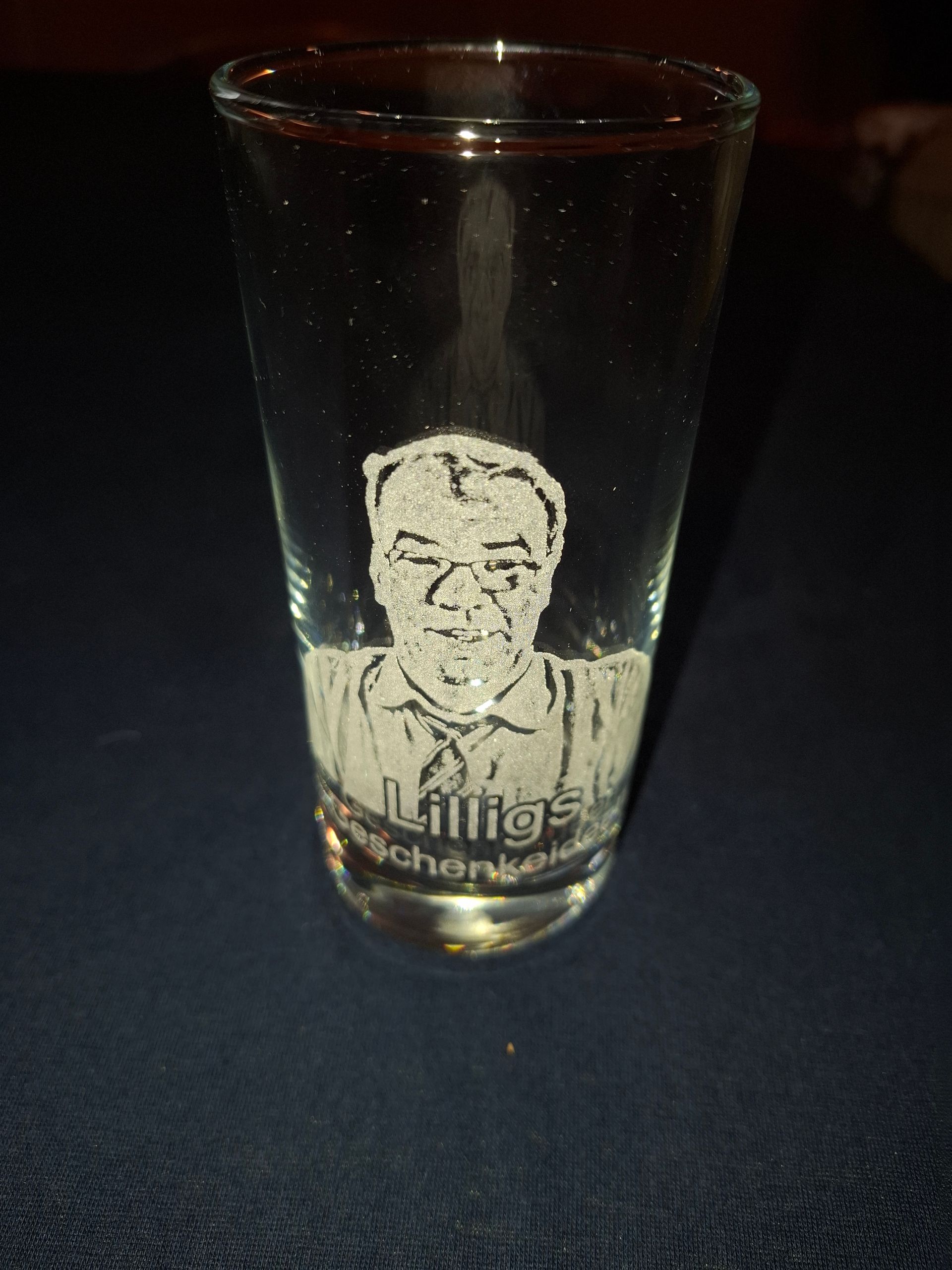 Ein Schnapsglas mit einem Bild eines Mannes darauf.