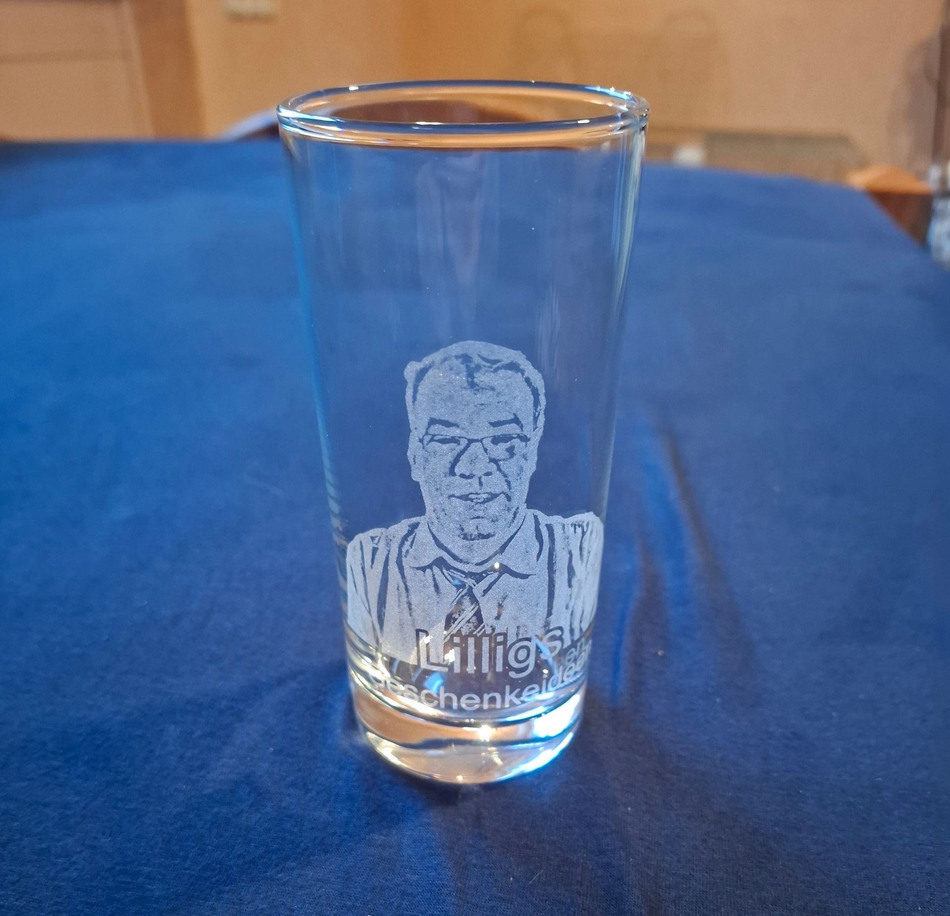 Ein Schnapsglas mit einem Bild eines Mannes darauf.