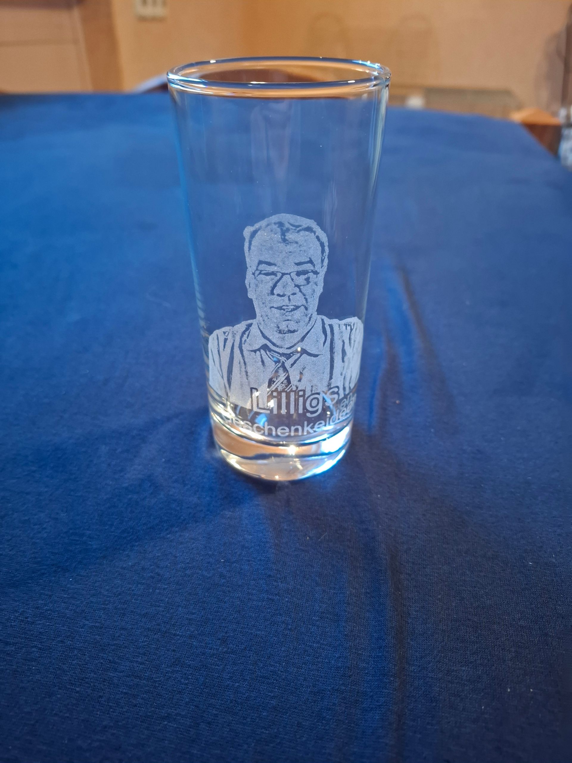 Ein leeres Weinglas steht auf einem Holztisch.