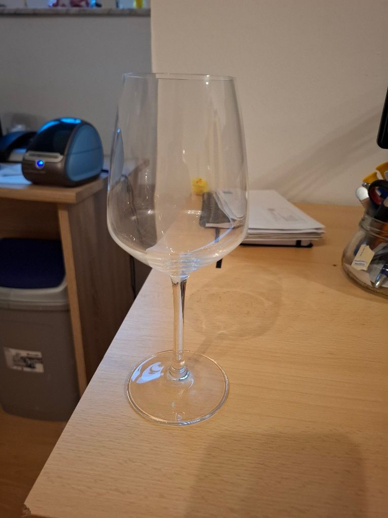 Ein leeres Weinglas steht auf einem Holztisch.