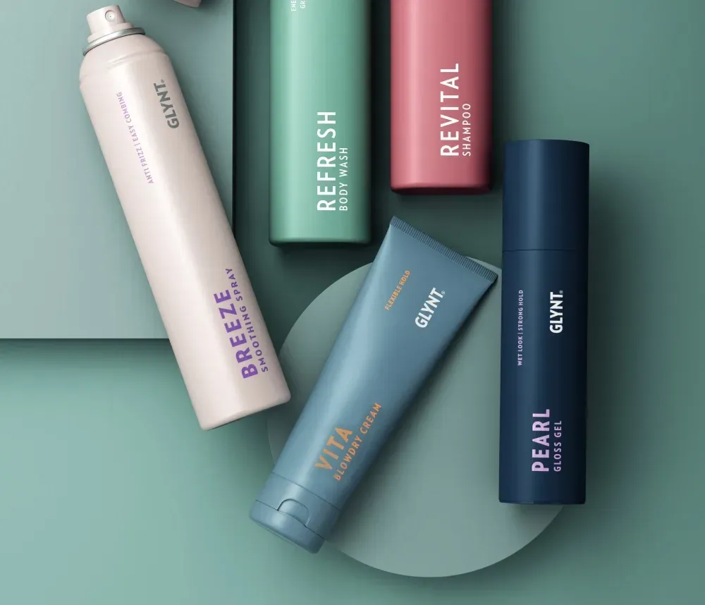 Un grupo de botellas de productos para el cabello están colocadas una encima de otra sobre una mesa.