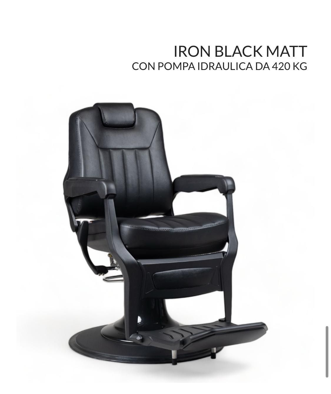 Una silla de barbero negra está colocada sobre una superficie blanca.