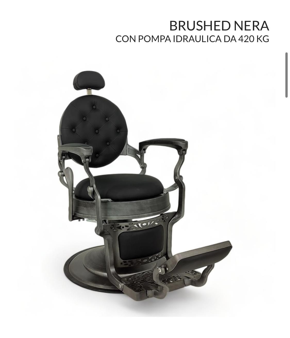 Una silla de barbero negra con un cojín negro sobre un fondo blanco.