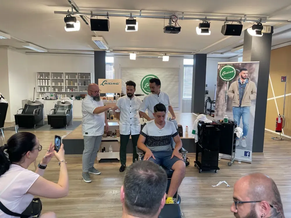 Una mujer está tomando una fotografía de un hombre que se está cortando el pelo en una peluquería.