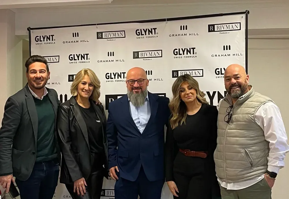 Un grupo de personas posa para una foto delante de una pancarta.