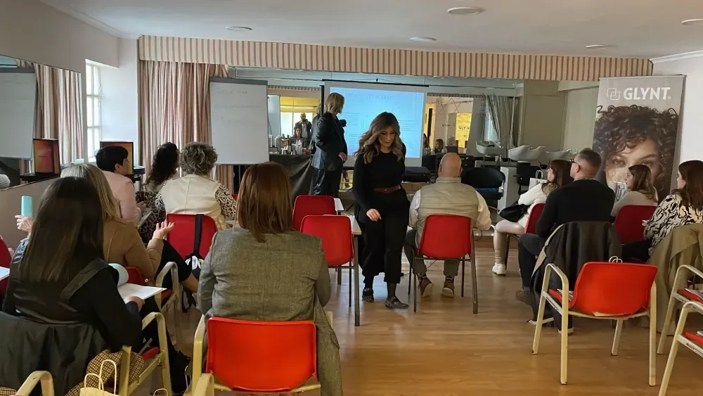 Un grupo de personas están sentadas en sillas rojas en una habitación.