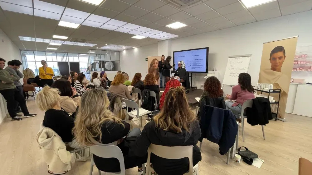 Un grupo de personas está sentada en una habitación viendo una presentación.