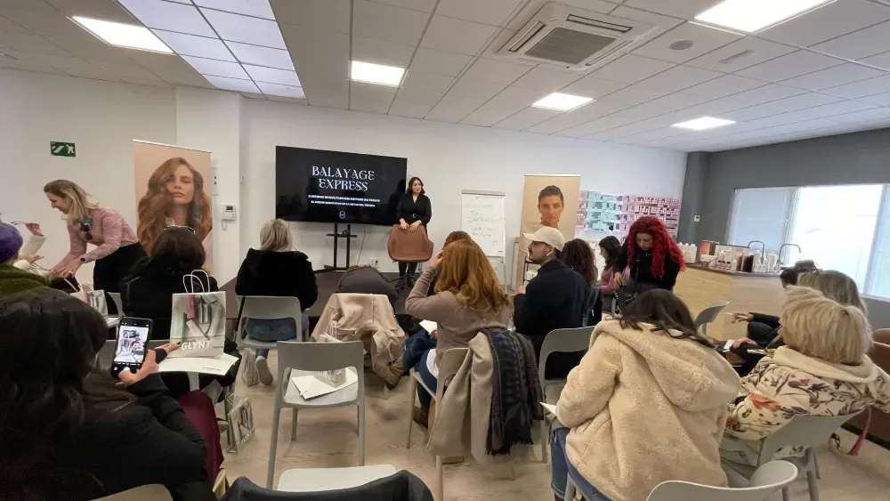 Un grupo de personas están sentadas en sillas en una habitación.