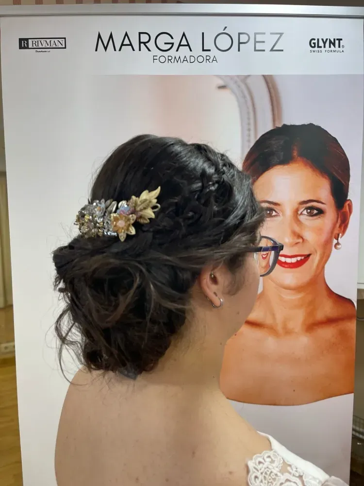 Una mujer con gafas está parada frente a un cartel que dice Marga López.