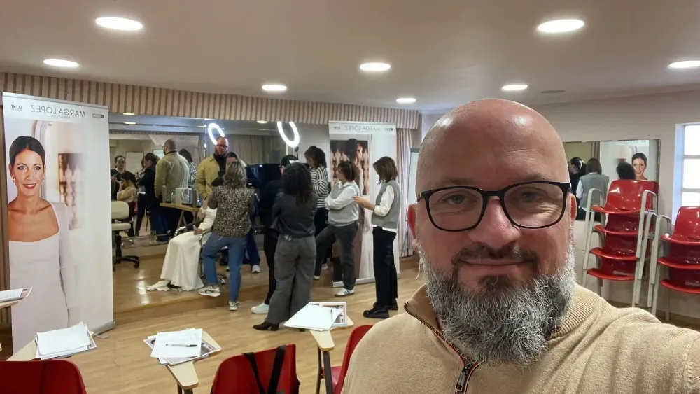 Un hombre con barba y gafas se está tomando un selfie en una habitación.
