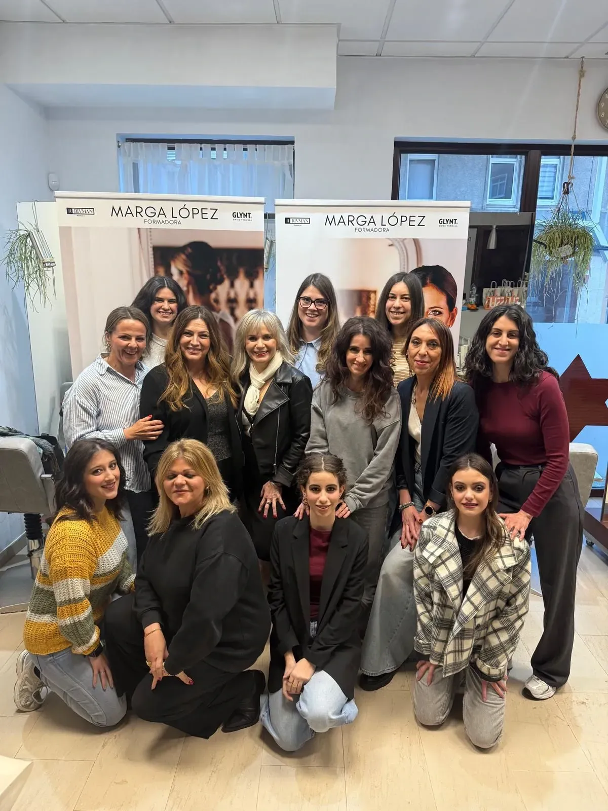 Un grupo de mujeres posa para una fotografía en un salón.