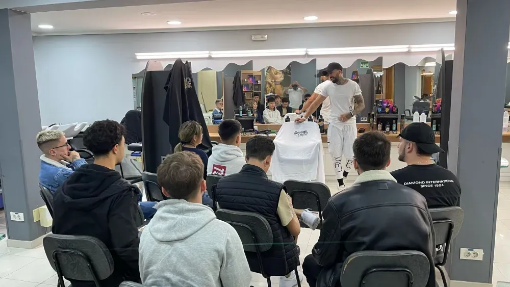 Un grupo de personas están sentadas en sillas en una barbería.