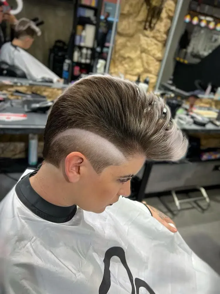 Un niño pequeño se está cortando el pelo en una barbería.