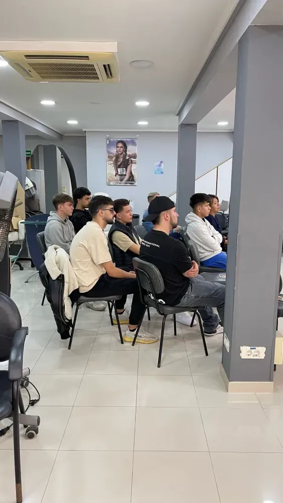 Un grupo de personas están sentadas en sillas en una habitación.