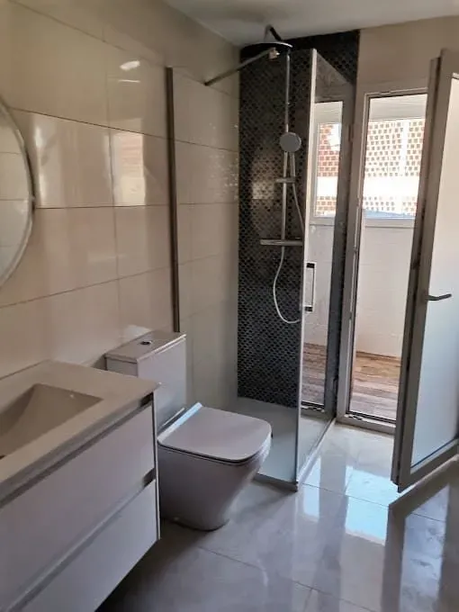 Un baño con inodoro, lavabo y ducha.